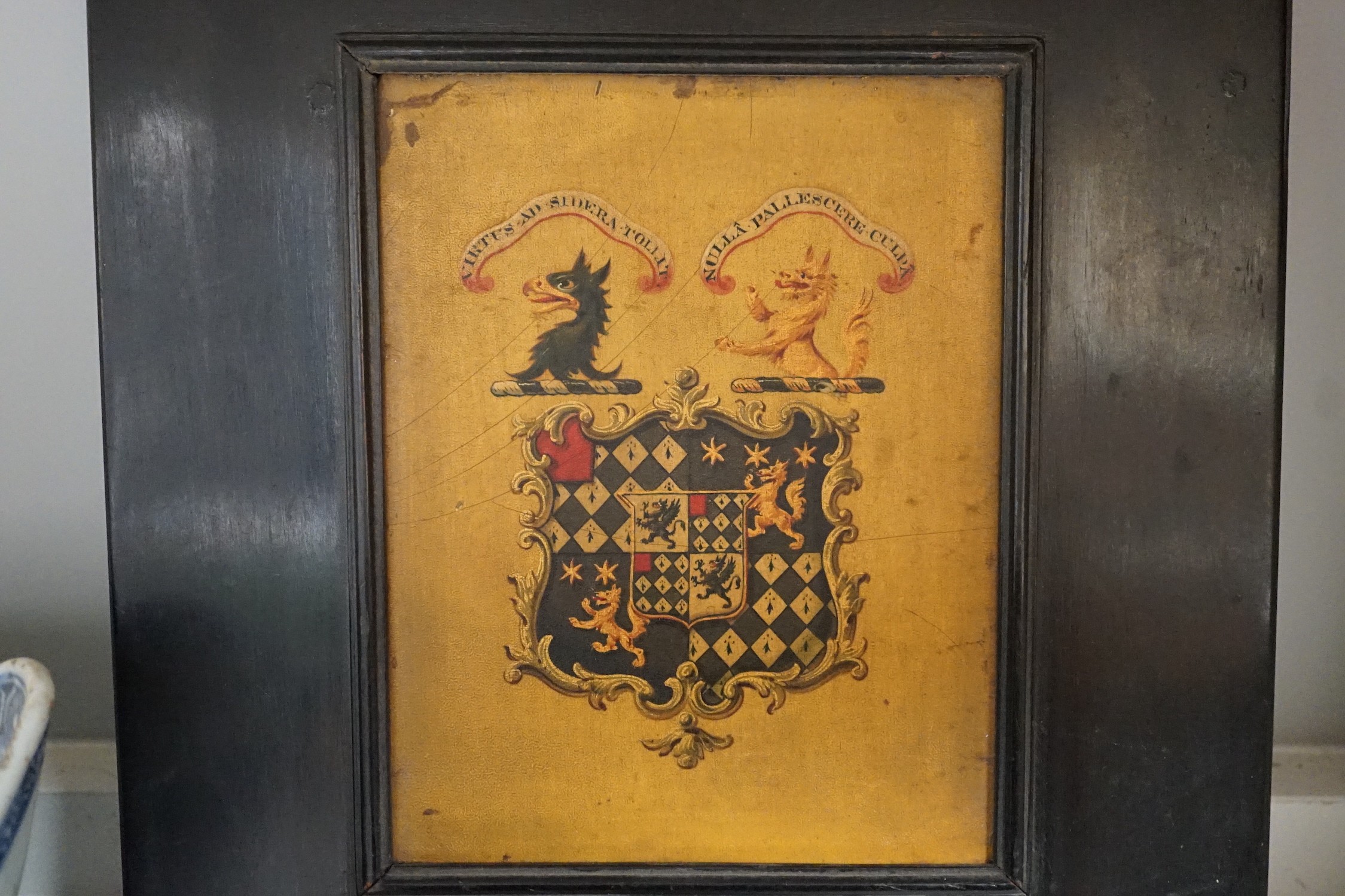 Four 19th century painted and ebonised heraldic wall brackets together with a 19th century armorial plaque